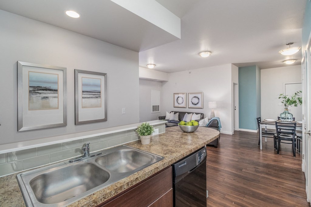 a kitchen with a sink and a counter top and a living room