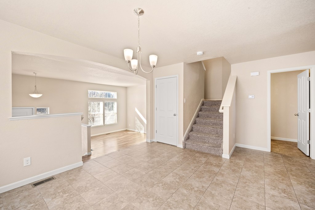 A spacious living room with a staircase leading to the second floor.