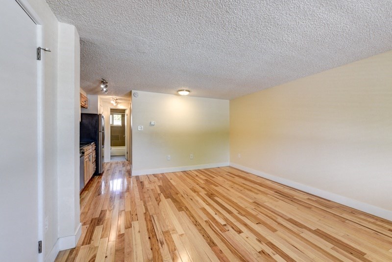 the spacious living room and dining room with hard wood flooring