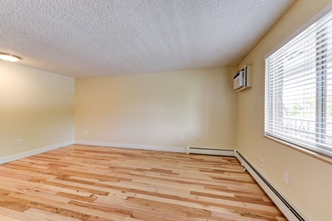 the spacious living room with wood flooring and large windows