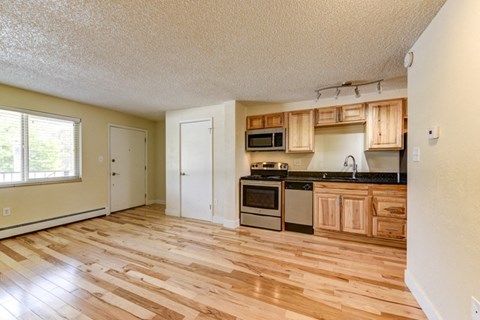 an empty kitchen with wooden floors and wooden cabinets