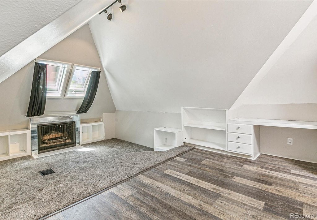 A room with a fireplace and a desk.