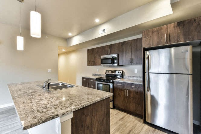 a kitchen with stainless steel appliances and a marble counter top