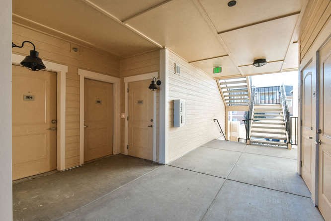 an empty hallway with doors and stairs in a building