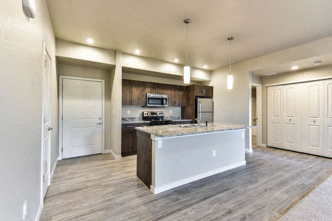 a large kitchen with a counter top and a refrigerator