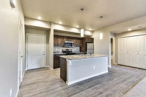 a large kitchen with a counter top and a refrigerator