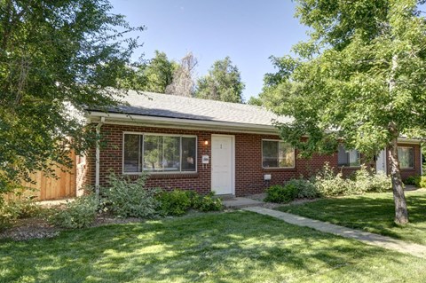A red brick house with a white door and windows.