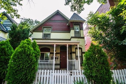 A house with a red roof and white picket fence.