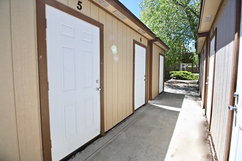 A series of small wooden buildings with numbered doors.