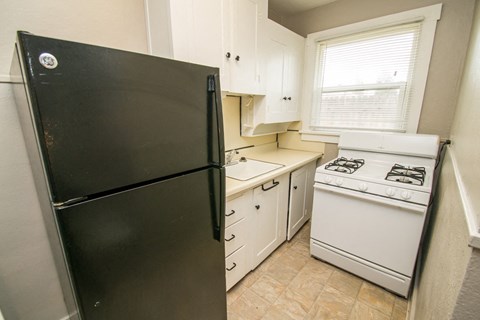 a kitchen with white appliances and a black refrigerator