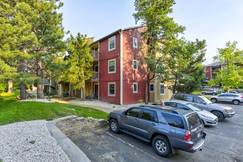 A red building with a grey car parked in front.