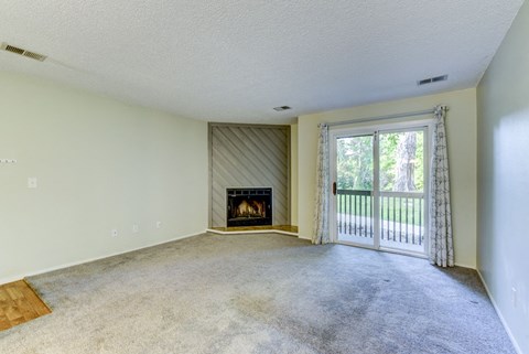 A living room with a fireplace and a sliding glass door.