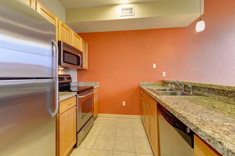 the kitchen has granite counter tops and stainless steel appliances
