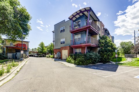 A street view of a residential area with a multi-story building on the right.