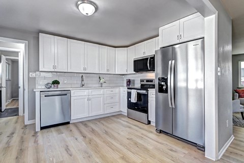 A kitchen with white cabinets and stainless steel appliances.