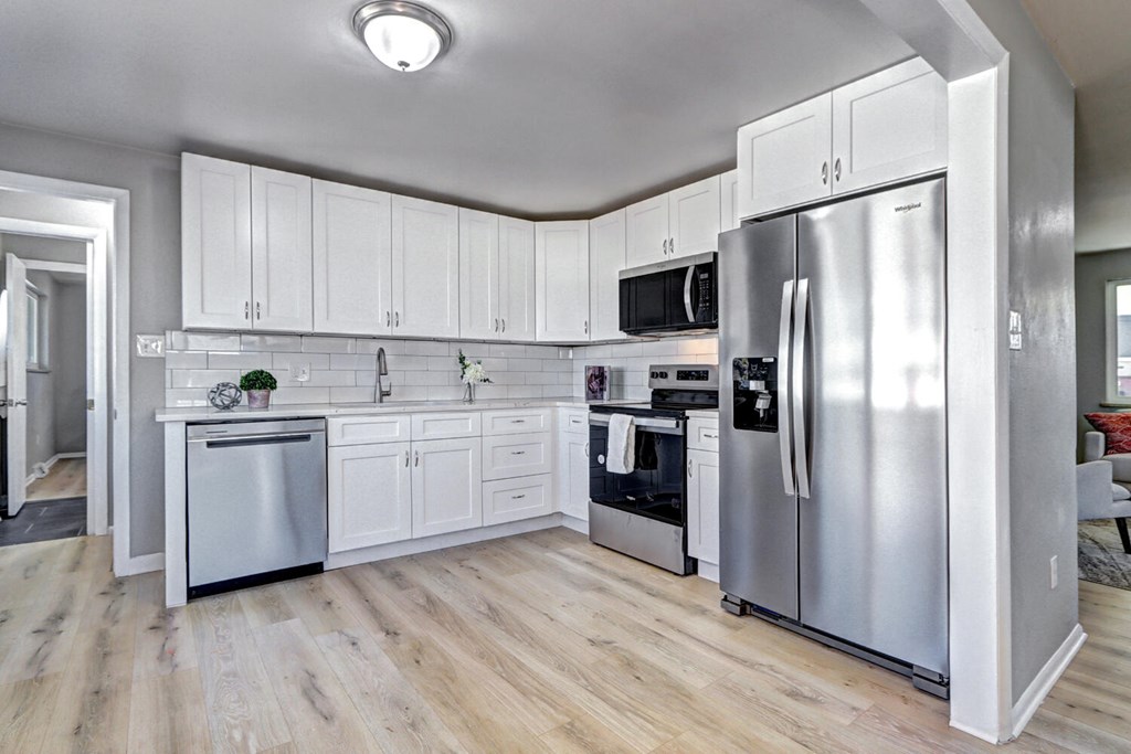 A kitchen with white cabinets and stainless steel appliances.