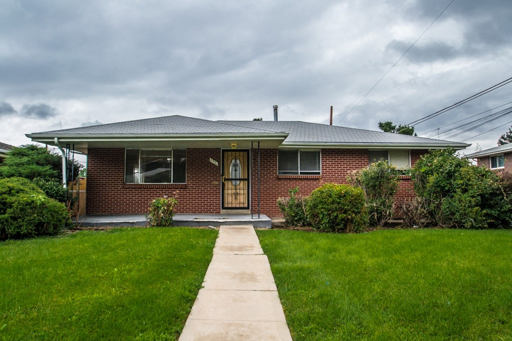 a red brick house with a sidewalk in front of it