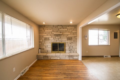 a living room with a brick fireplace and a large window