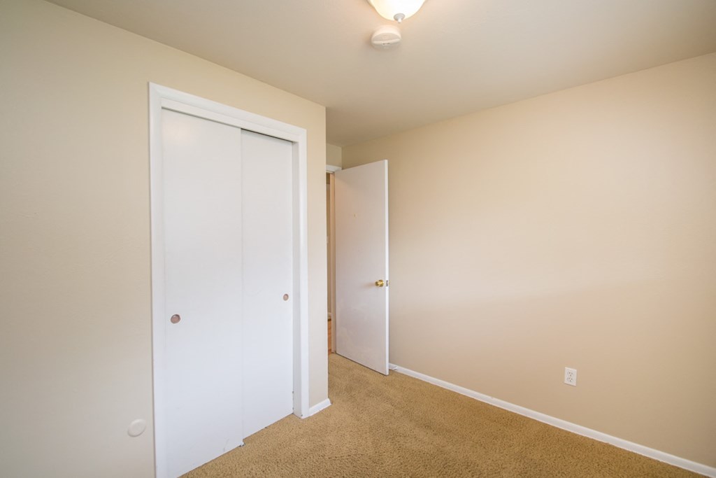 a bedroom with a closet and a door to a bathroom