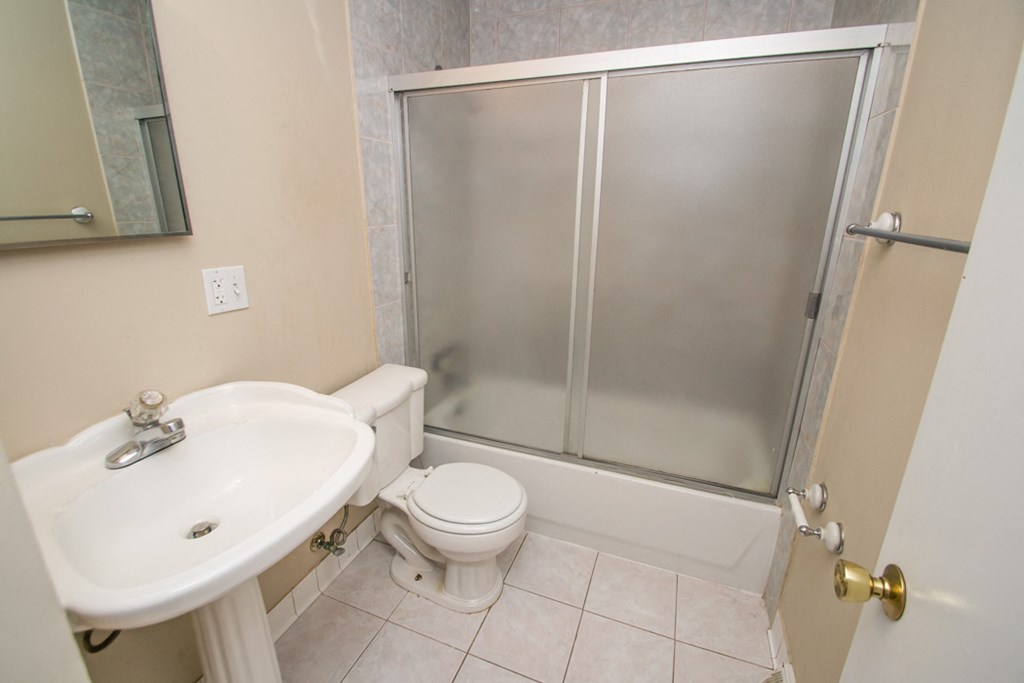 a bathroom with a shower and a sink and a toilet