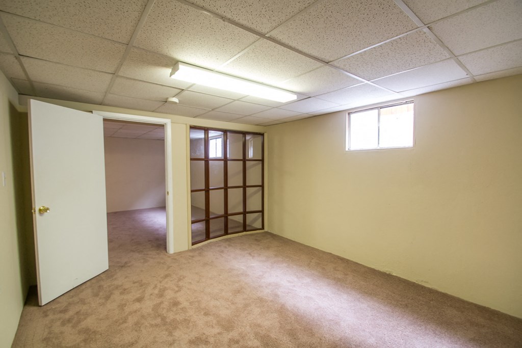 an empty room with a door to a closet and a window