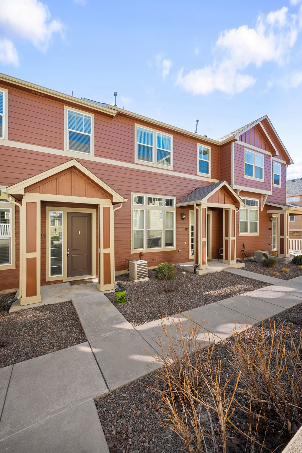 A row of houses with brown and red siding.