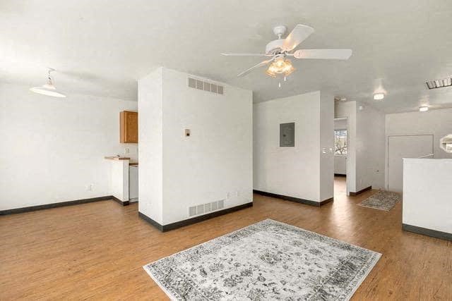 an empty living room with a ceiling fan