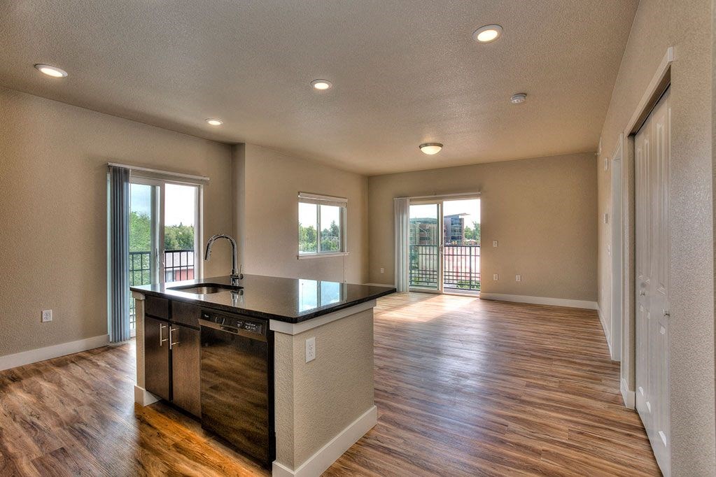 an empty kitchen and living room with a counter top