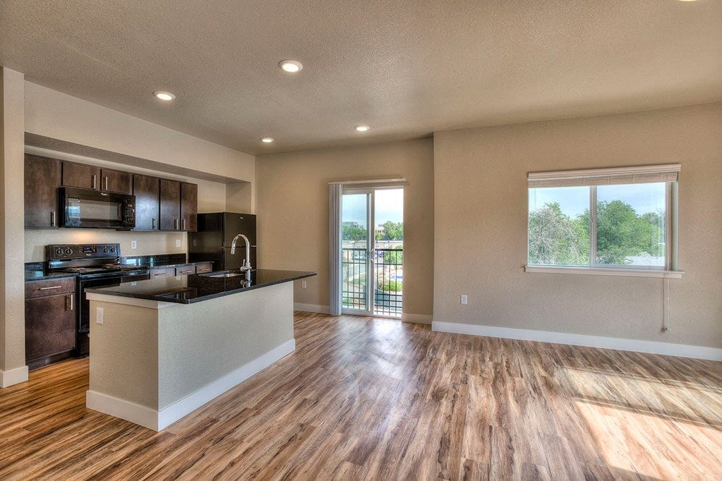 a living room with a kitchen and a window