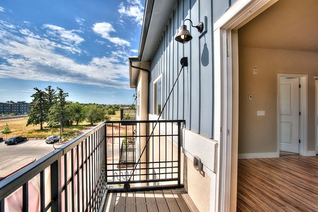 a balcony with a view of a city and a blue sky