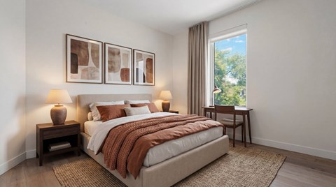 A bedroom with a large bed and a window showing trees outside.