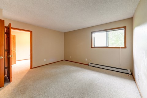 an empty living room with a window and a door