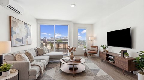 A modern living room with a large window and a flat screen TV.