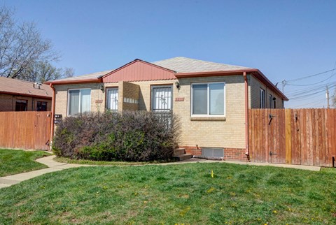 A house with a red roof and a fence.