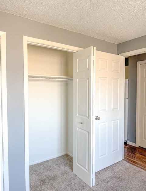A white door is open in a room with a carpeted floor.