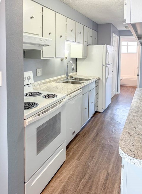 A kitchen with white appliances and cabinets.