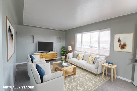A living room with a white couch and a wooden coffee table.