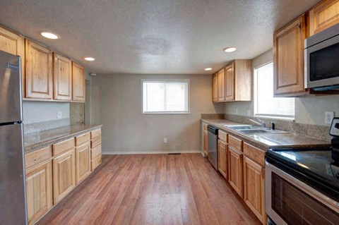a kitchen with wooden cabinets and a stove and a sink