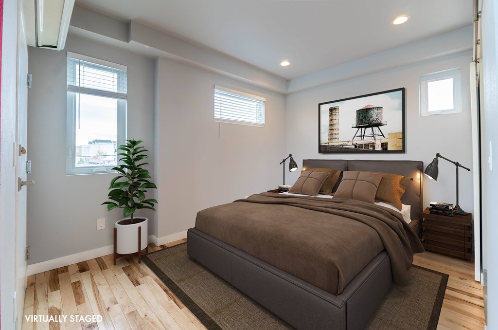 A bedroom with a large bed and a painting on the wall.