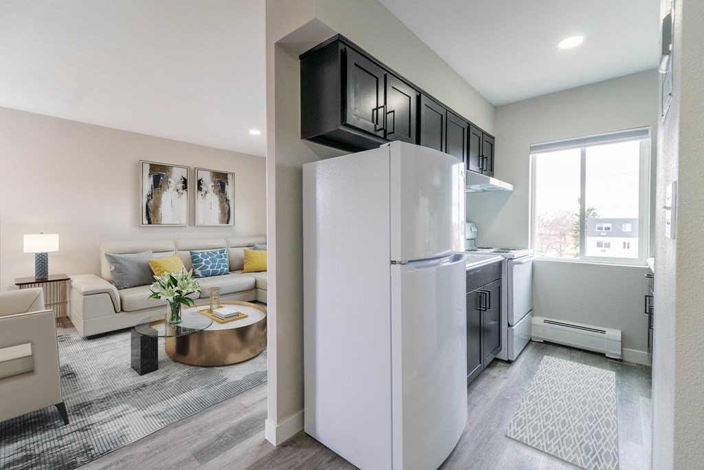 a kitchen and living room with a refrigerator and a window