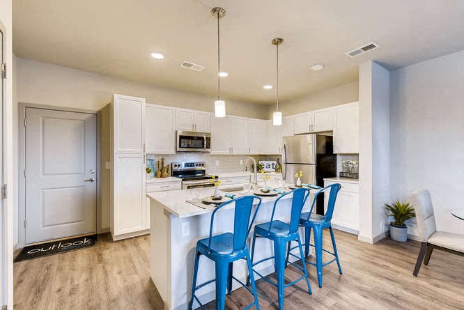 a kitchen with a island and blue chairs
