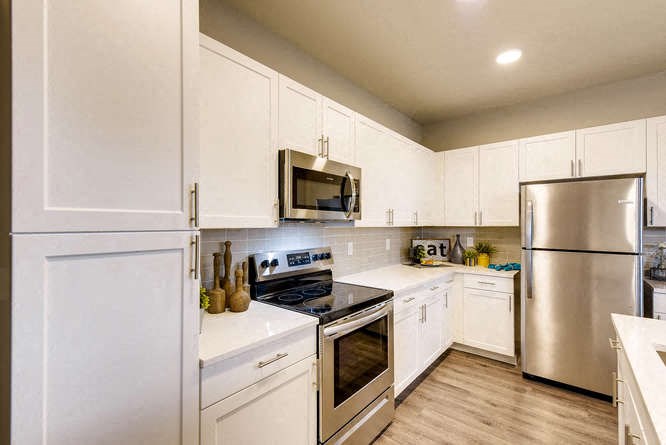 a kitchen with stainless steel appliances and white cabinets