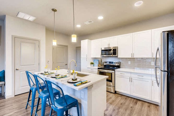 a kitchen with a island and blue chairs