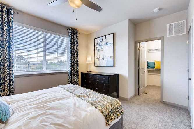 a bedroom with a bed and a ceiling fan