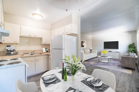 A modern kitchen with a dining table set for two.