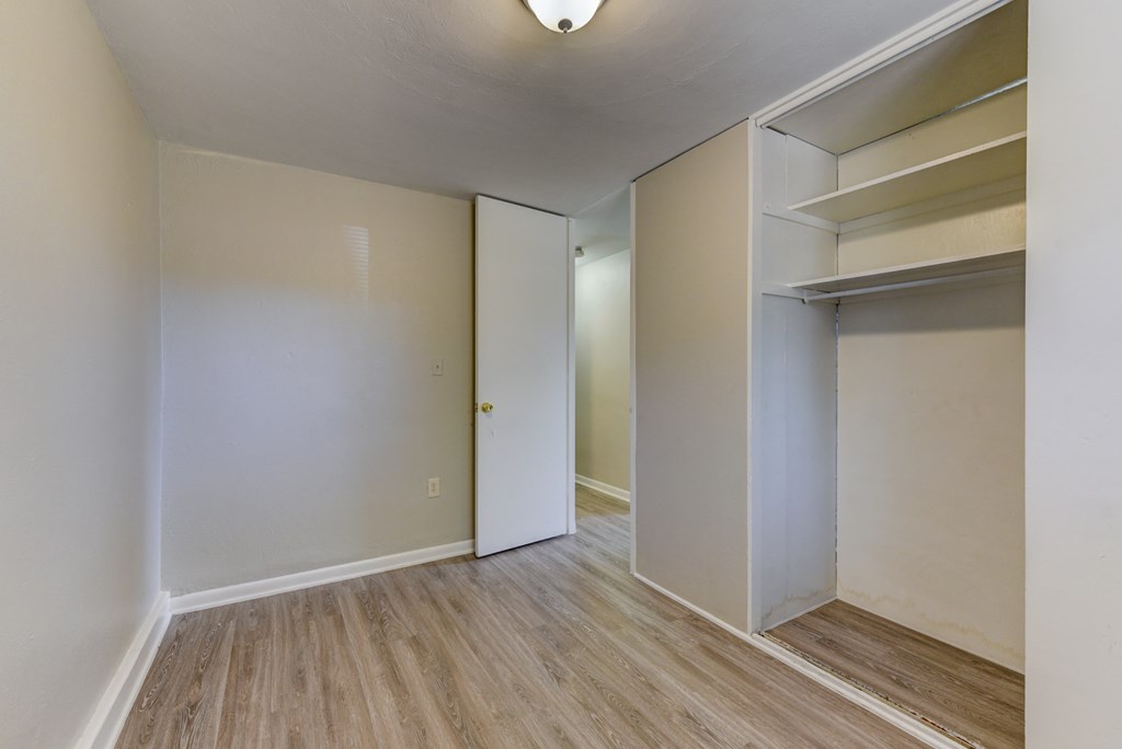 an empty room with white walls and a closet