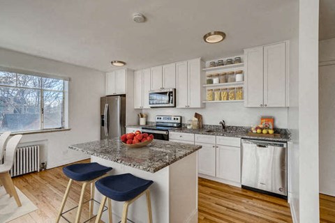 A kitchen with white cabinets and a granite countertop.