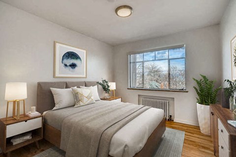A bedroom with a large bed and a window with a view of trees outside.