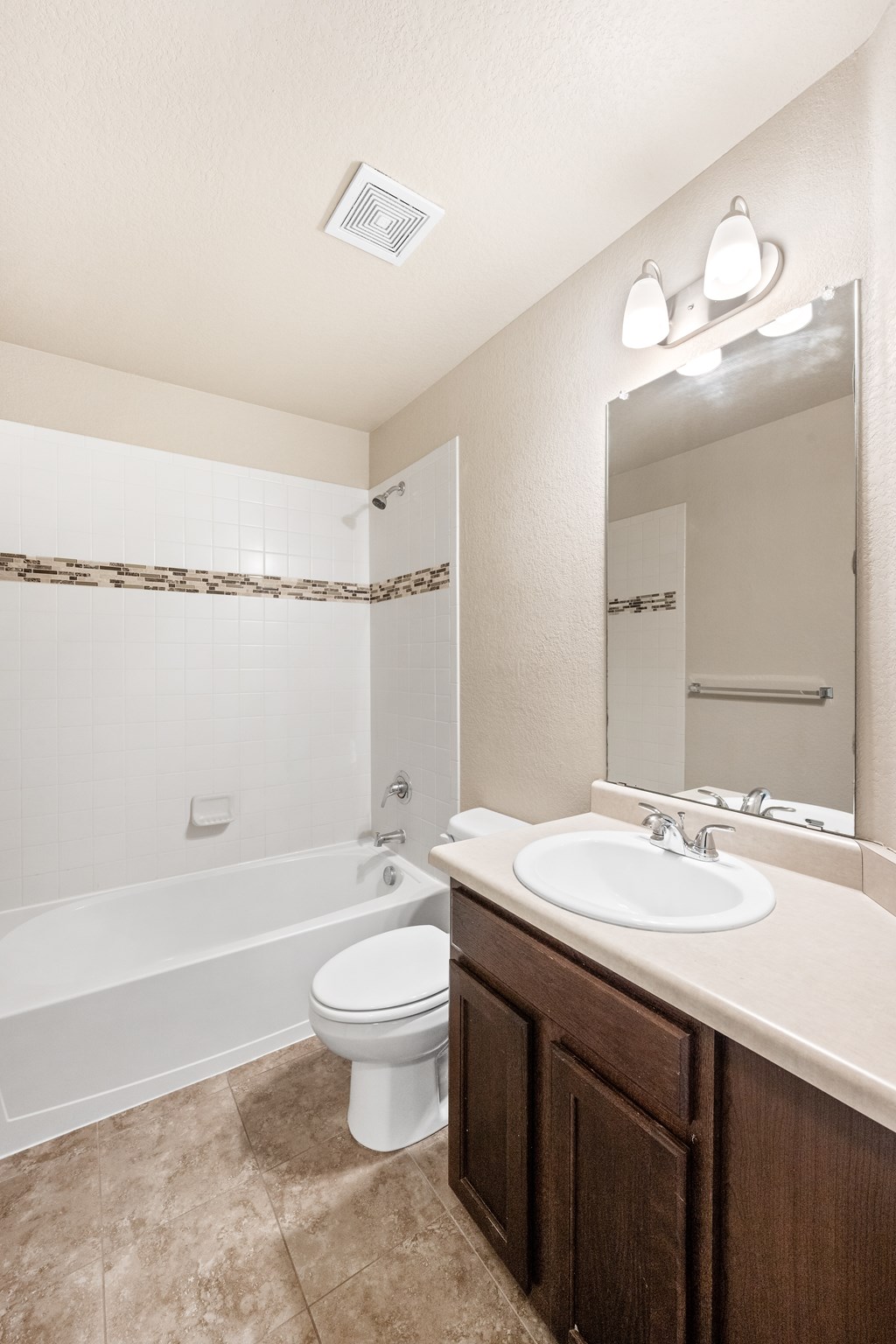A white toilet sits in a bathroom next to a sink.