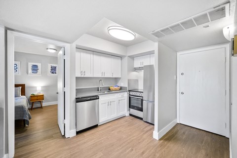 a renovated kitchen with white cabinets and stainless steel appliances